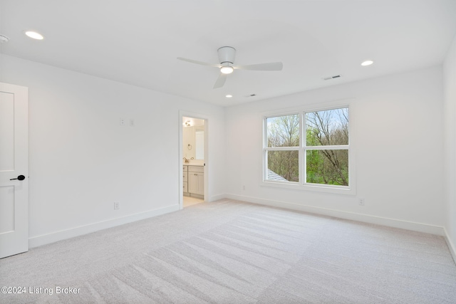 unfurnished bedroom with ceiling fan, light carpet, and ensuite bathroom