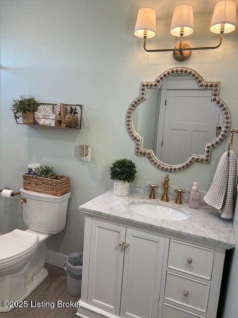 bathroom featuring hardwood / wood-style flooring, toilet, and vanity