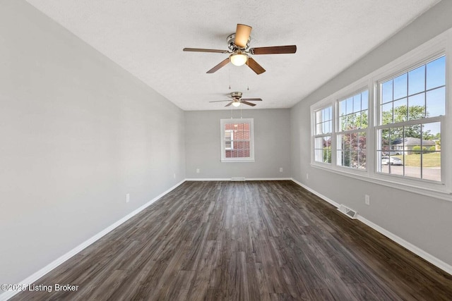 empty room with dark wood-type flooring and a textured ceiling