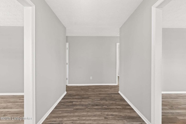 hall featuring dark hardwood / wood-style floors and a textured ceiling