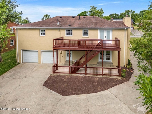 back of house featuring a wooden deck and a garage