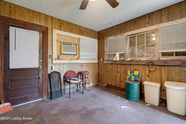 interior space featuring a wall unit AC and ceiling fan