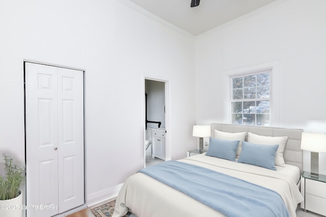 bedroom with light hardwood / wood-style flooring, ceiling fan, connected bathroom, ornamental molding, and a closet