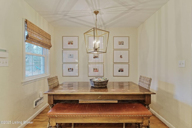 dining area featuring wood-type flooring and a chandelier