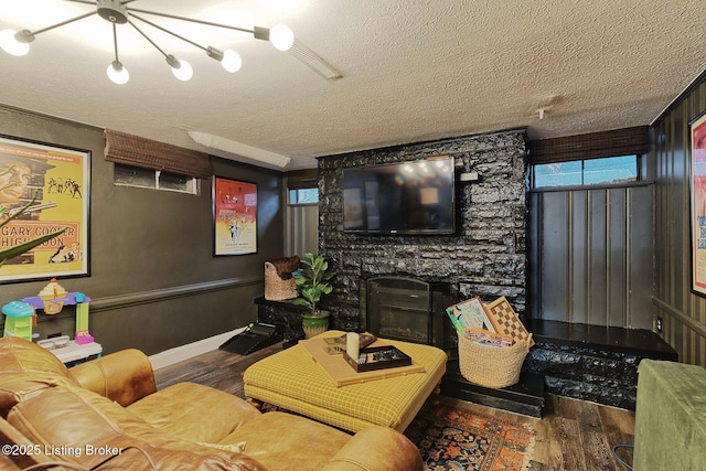 living room featuring a textured ceiling, dark hardwood / wood-style floors, and a fireplace