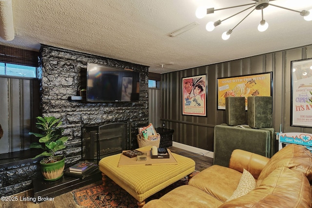 living room featuring a textured ceiling, hardwood / wood-style floors, and a fireplace