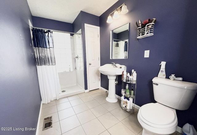 bathroom with a shower with curtain, toilet, and tile patterned floors