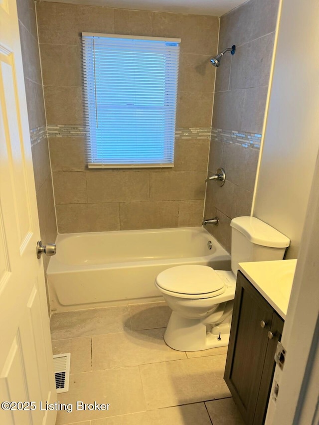 full bathroom with toilet, tile patterned flooring, tiled shower / bath, and vanity