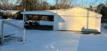 snow covered structure featuring a garage