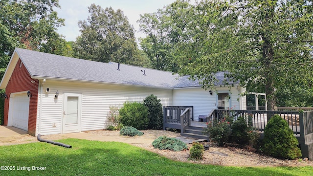 back of house featuring a wooden deck, a garage, and a lawn