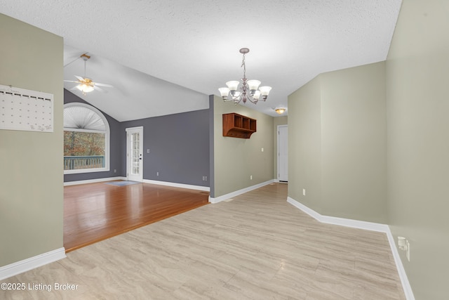 interior space featuring ceiling fan with notable chandelier, a textured ceiling, light hardwood / wood-style flooring, and lofted ceiling