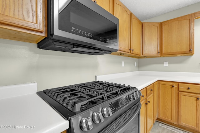 kitchen with appliances with stainless steel finishes and a textured ceiling