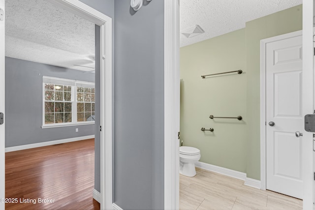 bathroom featuring a textured ceiling, toilet, and hardwood / wood-style flooring