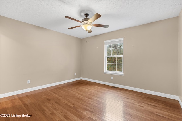 unfurnished room featuring ceiling fan, wood-type flooring, and a textured ceiling