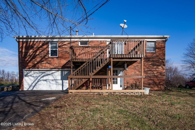 back of house with a lawn, a wooden deck, and a garage