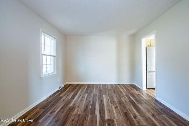 unfurnished room with dark hardwood / wood-style floors and a textured ceiling