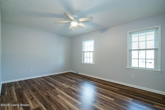 unfurnished room featuring a textured ceiling, ceiling fan, plenty of natural light, and dark hardwood / wood-style floors