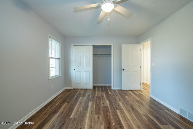 unfurnished bedroom with a closet, dark hardwood / wood-style floors, and ceiling fan