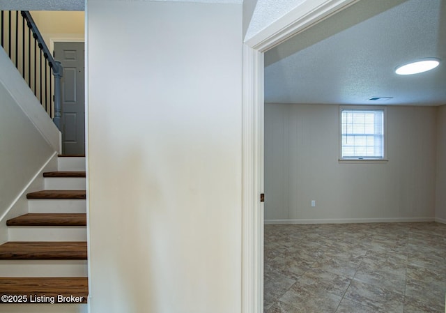 staircase with a textured ceiling