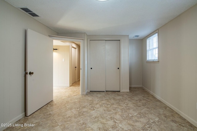 unfurnished bedroom with a textured ceiling and a closet