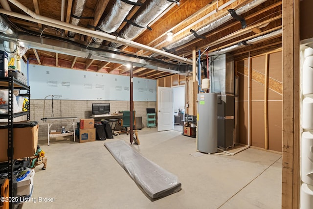 basement featuring water heater and brick wall