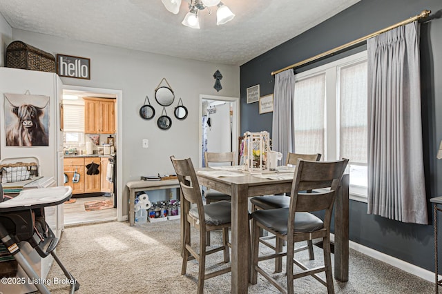 dining space featuring a textured ceiling, ceiling fan, and carpet flooring