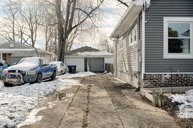 view of snow covered exterior with an outdoor structure and a garage