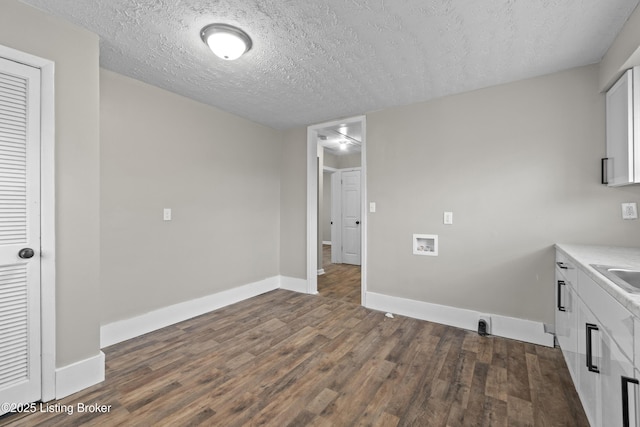 laundry room with baseboards, cabinet space, washer hookup, and dark wood finished floors