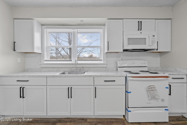 kitchen featuring a sink, white appliances, tasteful backsplash, and white cabinets