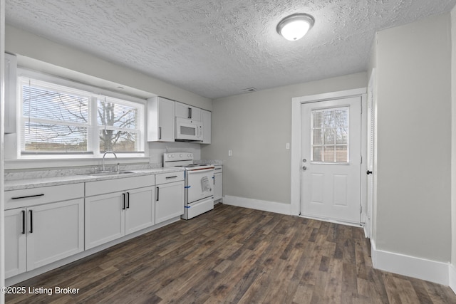 kitchen with white appliances, dark wood-style floors, baseboards, a sink, and light countertops