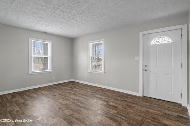 entryway with dark wood-style floors, a textured ceiling, and baseboards