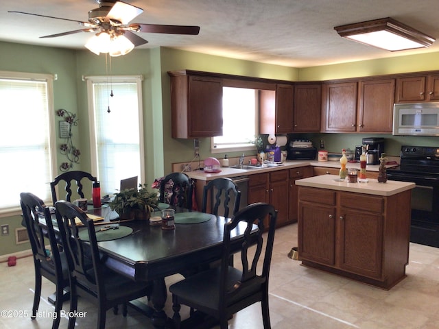 kitchen with sink, electric range, ceiling fan, and a kitchen island