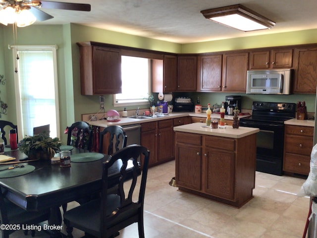 kitchen featuring ceiling fan, stainless steel appliances, sink, and a kitchen island