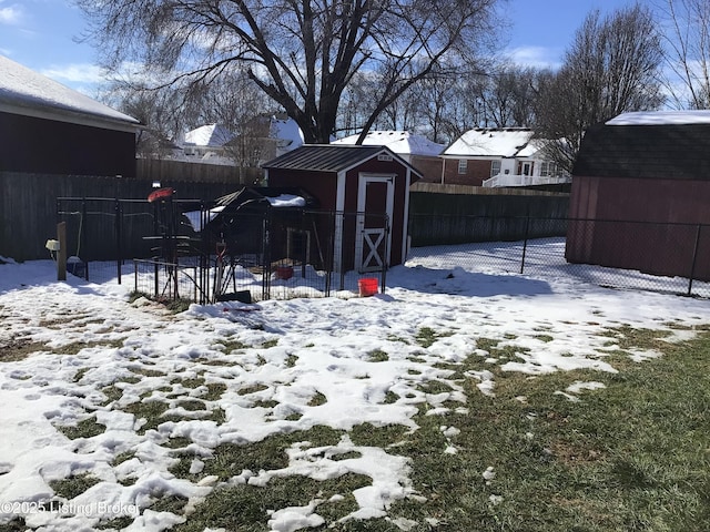 snowy yard featuring a shed