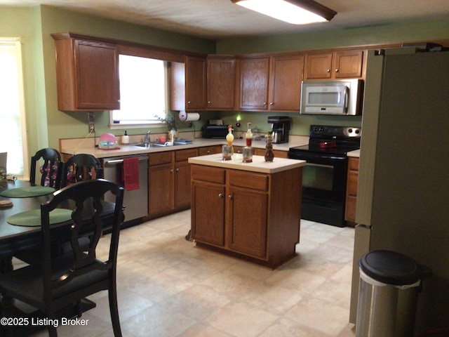 kitchen with appliances with stainless steel finishes, a center island, and sink