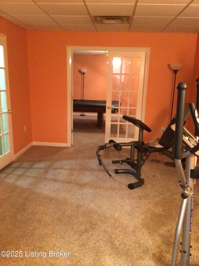 workout area featuring carpet floors, a drop ceiling, and french doors