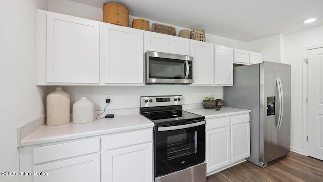 kitchen featuring stainless steel appliances, dark hardwood / wood-style flooring, and white cabinets