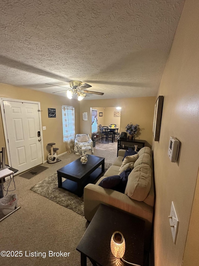 carpeted living room featuring ceiling fan and a textured ceiling