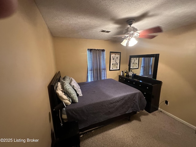 bedroom with ceiling fan, carpet floors, and a textured ceiling