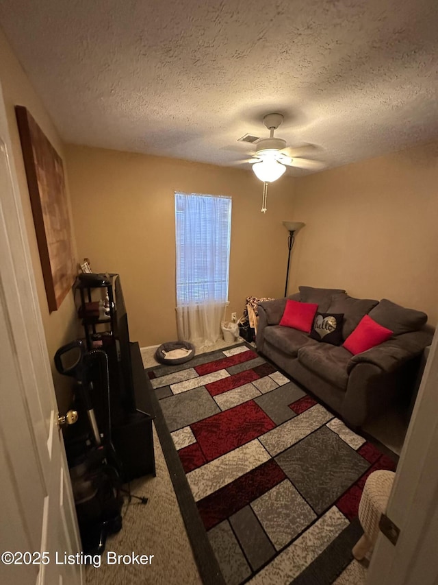 carpeted bedroom featuring a textured ceiling and ceiling fan