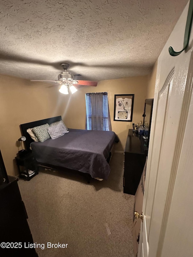 carpeted bedroom featuring ceiling fan and a textured ceiling