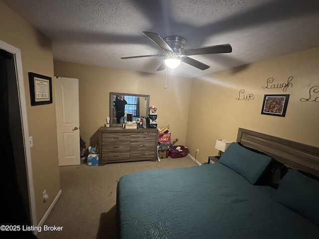 carpeted bedroom featuring ceiling fan and a textured ceiling