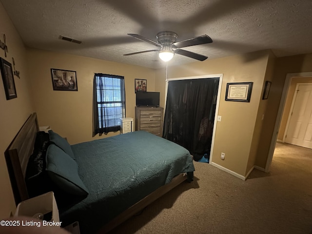 carpeted bedroom with ceiling fan and a textured ceiling