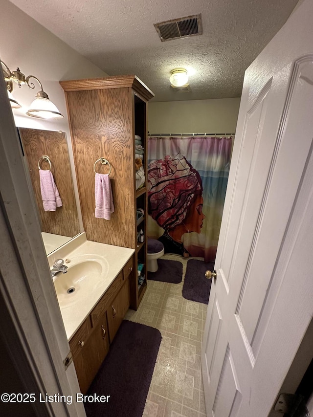 bathroom featuring a textured ceiling and vanity