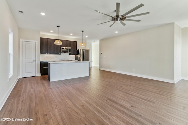 kitchen featuring visible vents, open floor plan, light countertops, light wood-style flooring, and appliances with stainless steel finishes