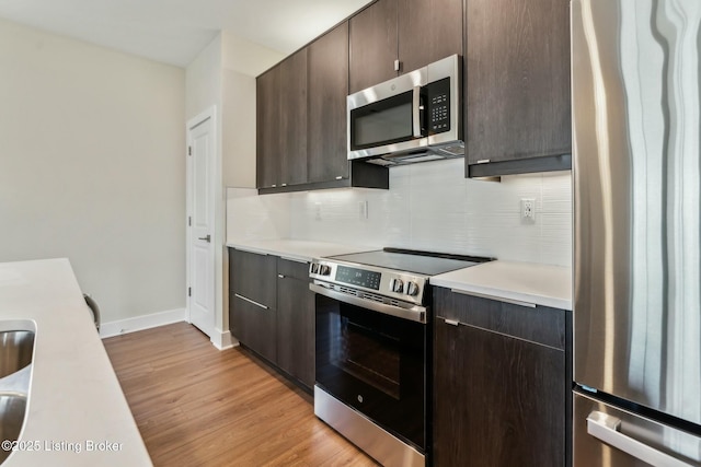 kitchen featuring tasteful backsplash, dark brown cabinetry, appliances with stainless steel finishes, and light countertops