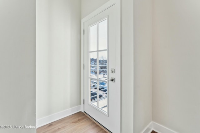 doorway to outside with light wood-style floors, baseboards, and a wealth of natural light