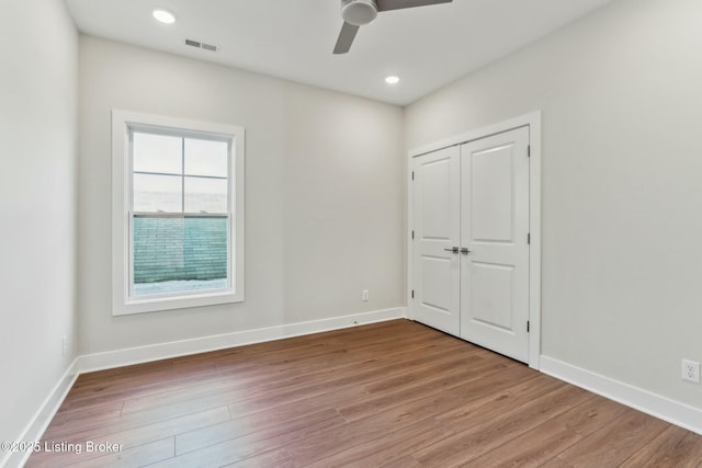 unfurnished bedroom with visible vents, baseboards, and wood finished floors