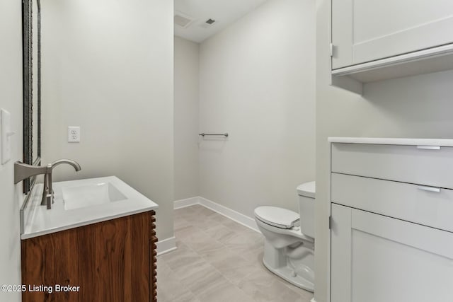 bathroom featuring visible vents, toilet, vanity, and baseboards