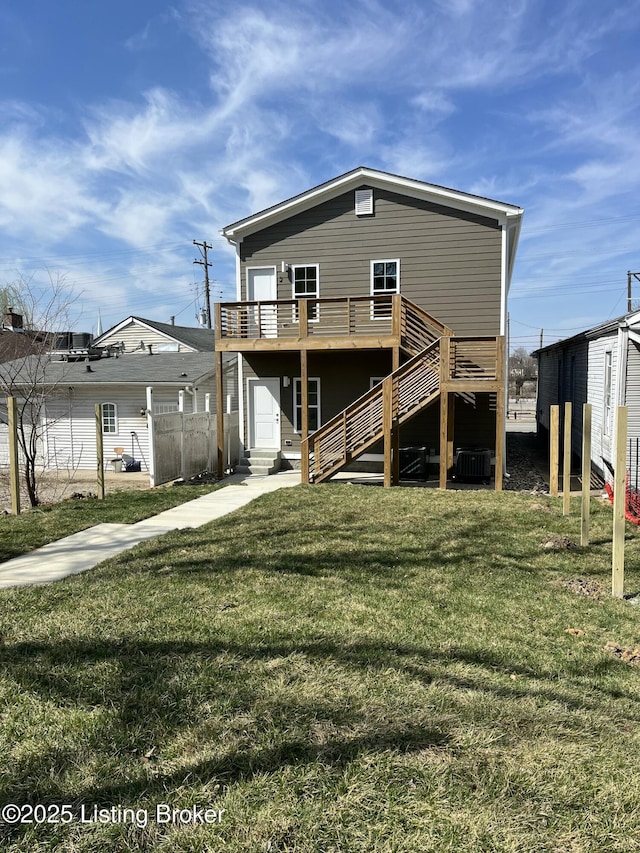 back of house with entry steps, fence, a yard, a wooden deck, and stairs